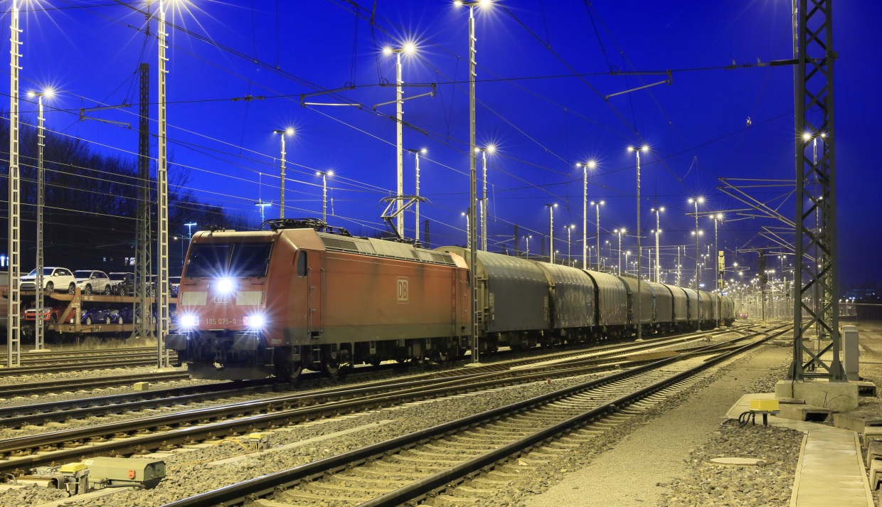 Eine Ellok der Baureihe 185 TRAXX steht im abendlichen Aachen West Gbf abfahrbereit mit einem Stahl-Coil-Zug aus Belgien. (Foto: Â© DB AG / Uwe Miethe)